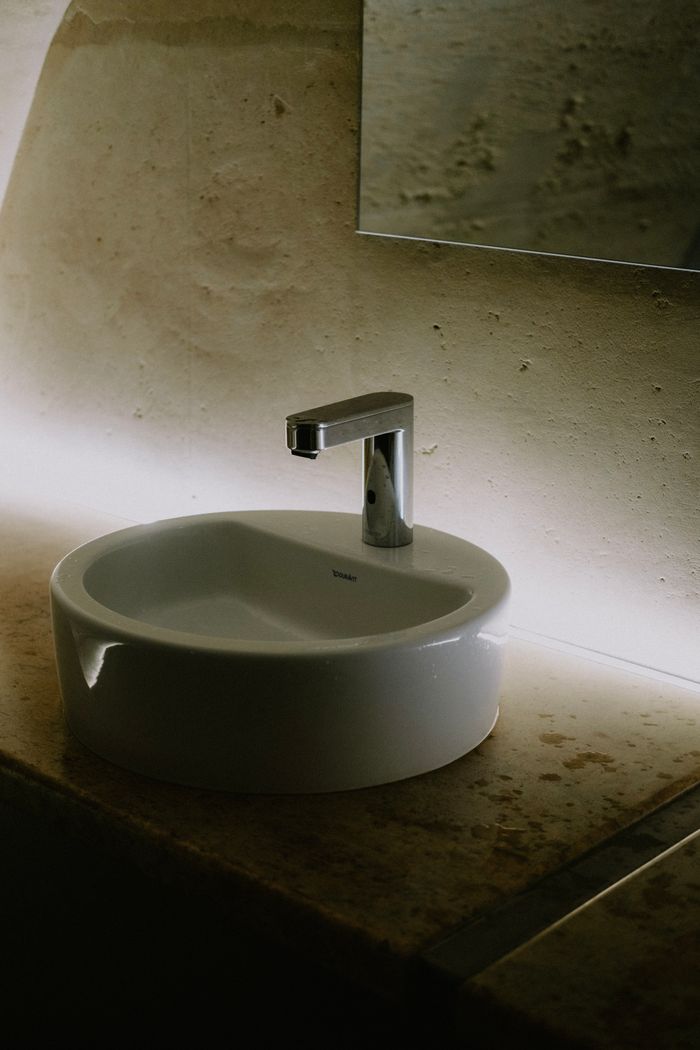 creative-03 Stylish bathroom sink featuring a sleek faucet and ambient lighting.