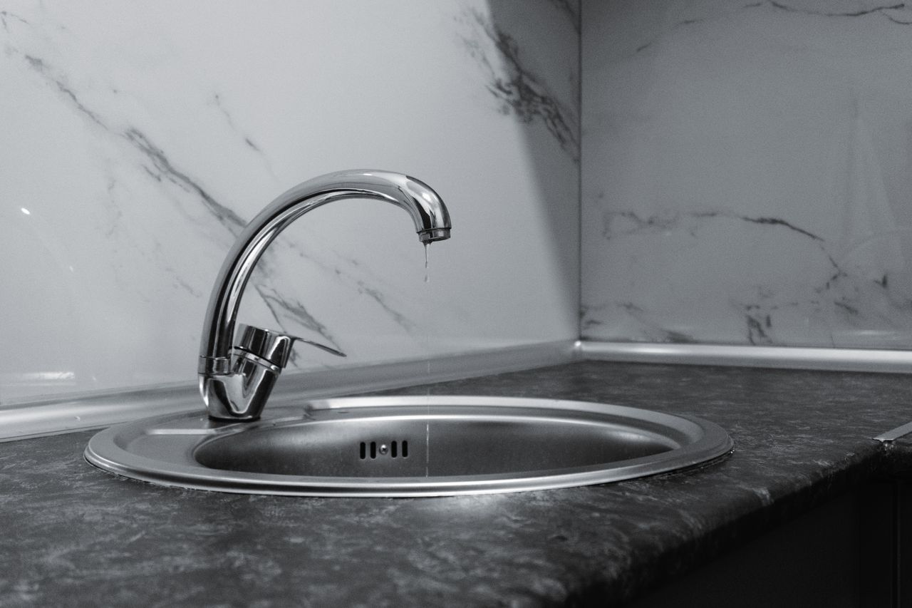 mobile-01 A clean and modern kitchen sink with a chrome faucet, highlighting minimalist design and water conservation.